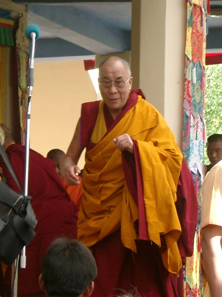 De Dalai Lama, in geel en rood, tussen de monniken
