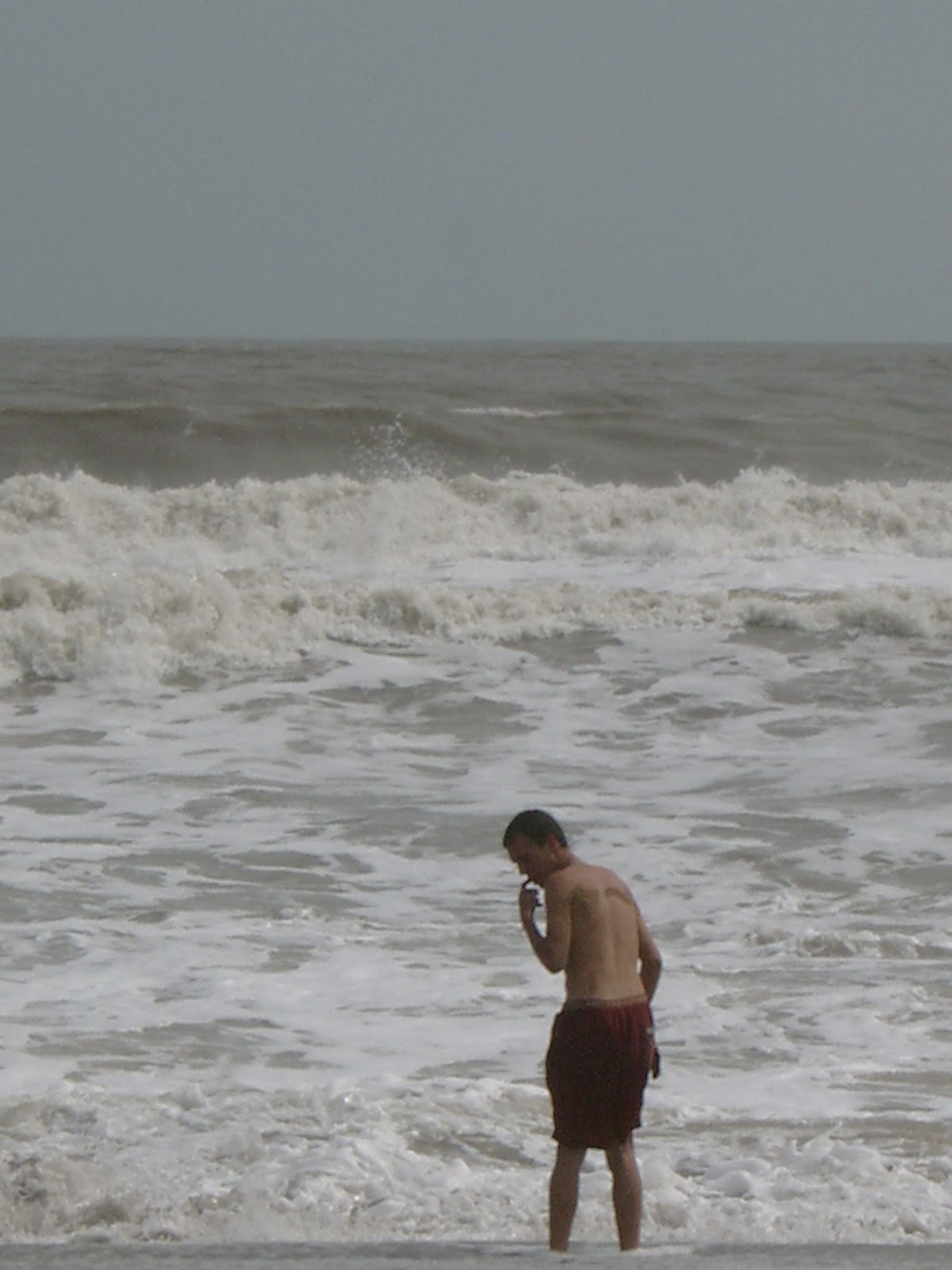 Wout in de huizenhoge moessongolven op het strand van Diu