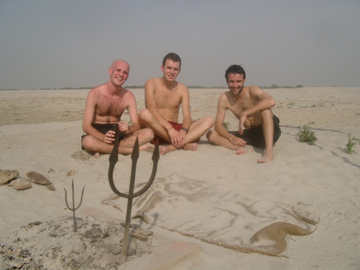 Drie zwemmers op een zandbank in de Ganges, met drietand