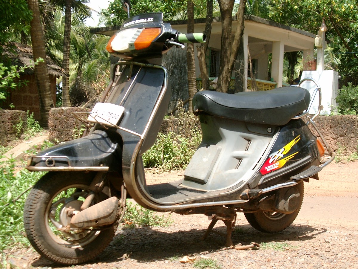 De gehuurde scooter op een strandweggetje in Goa