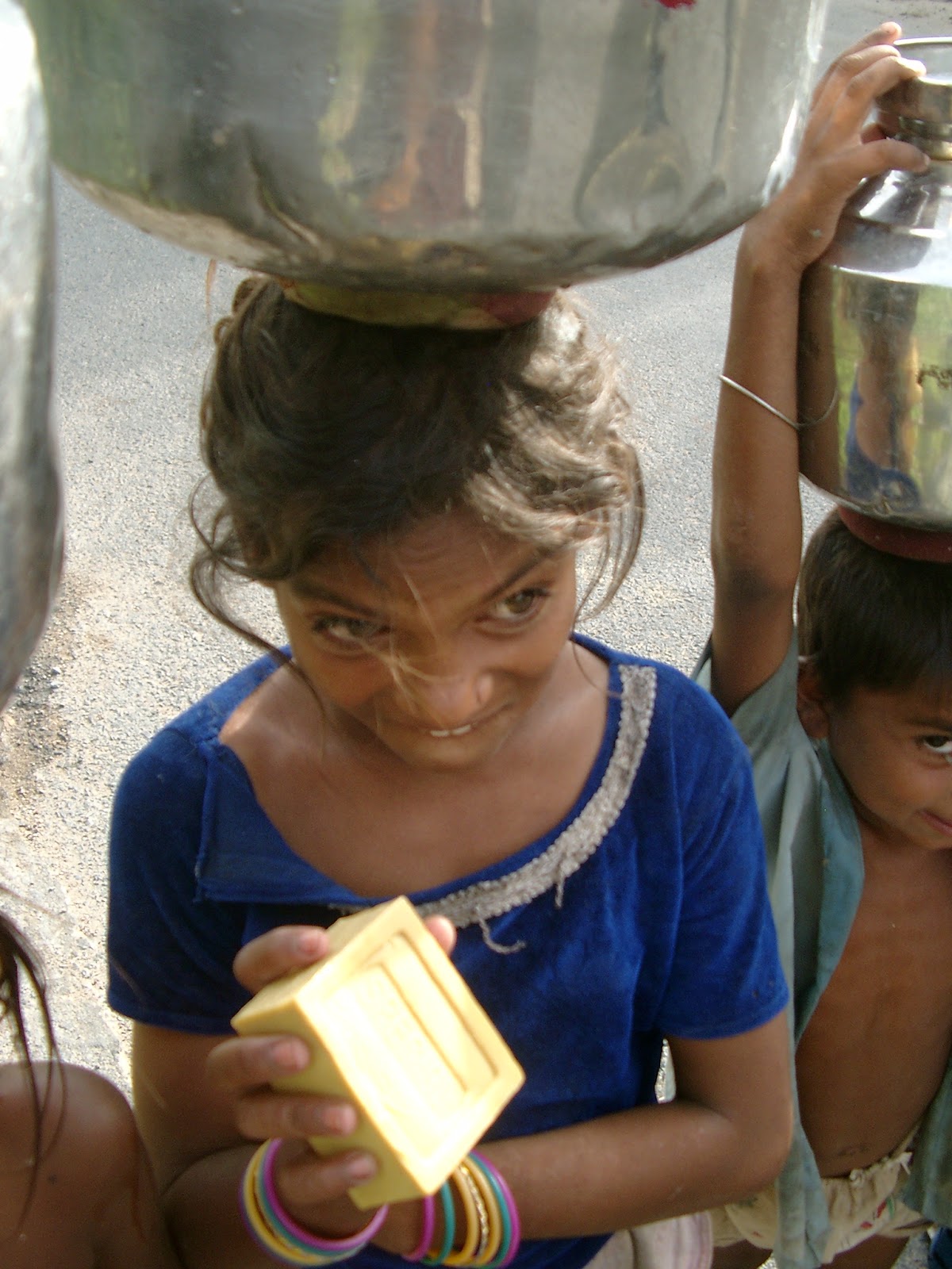 Lachende kinderen met glimmende waterpotten op hun hoofd in de oude stad van Jodhpur