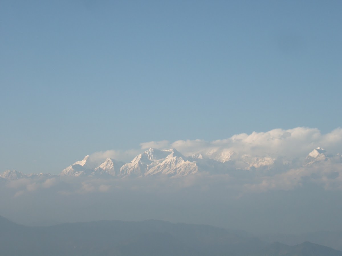 De besneeuwde Kanchenjunga boven een wolkenzee