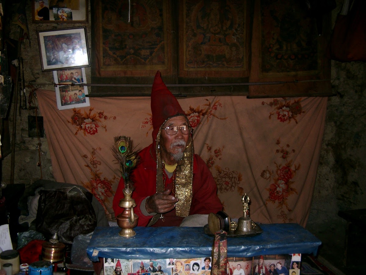 De lama in zijn met foto’s behangen kamer boven Manang