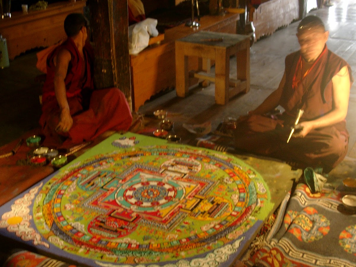 Monniken werken aan een kleurrijke zand-mandala in het klooster van Tiksay